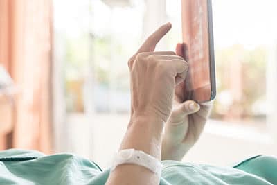 inpatient used tablet on bed in rehab center