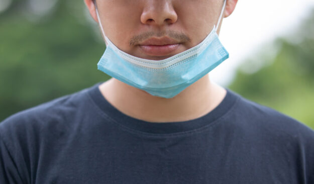 How to wear a mask. a men showing how to wearing wrong way a mask on the chin. Avoid Drug and Alcohol Relapse during covid 19